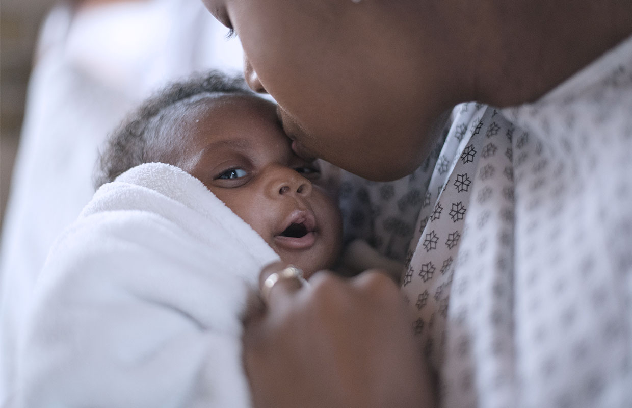 A mother kisses her newborn baby on the forehead after giving birth at a Covenant Health hospital.