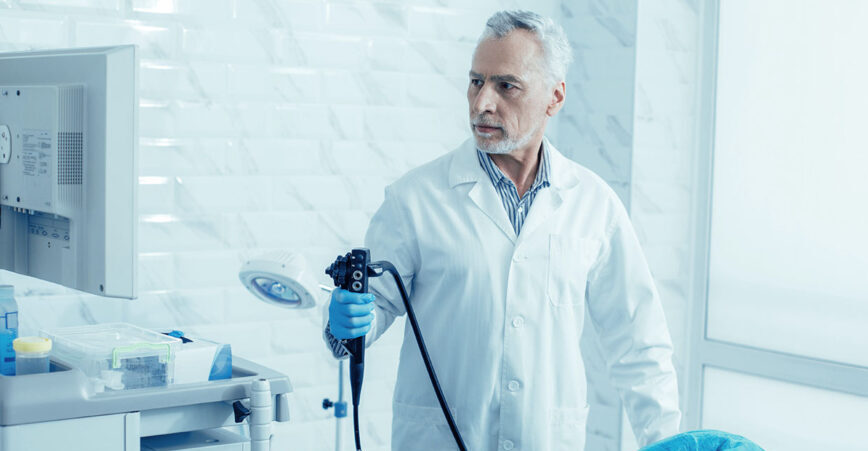 a gastroenterologist holds a medical device while performing a procedure on a patient