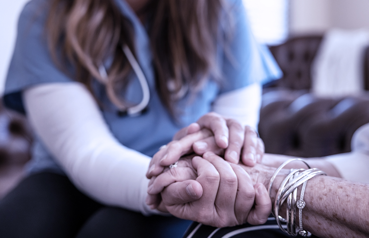 Comforting hands of healthcare staff supporting family.