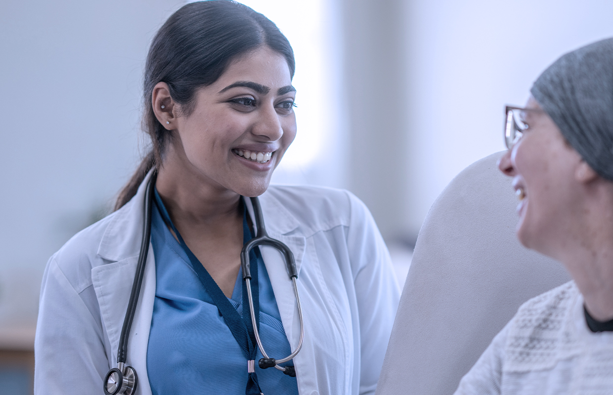 young female doctor smiles while talking to female patient