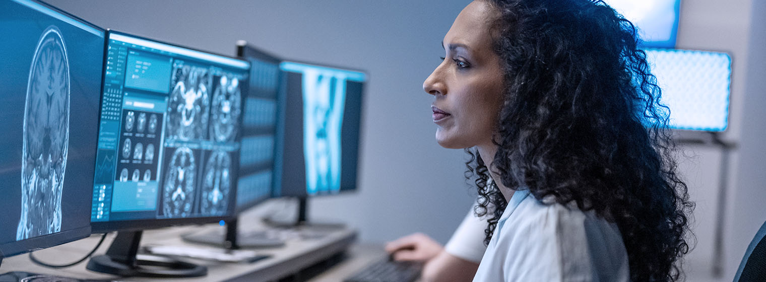 female physician looks at mri scans on computer screens