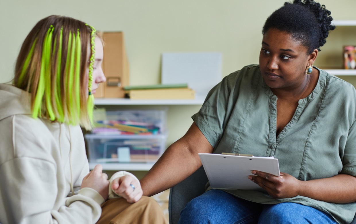 young female talks with female holding clipboard