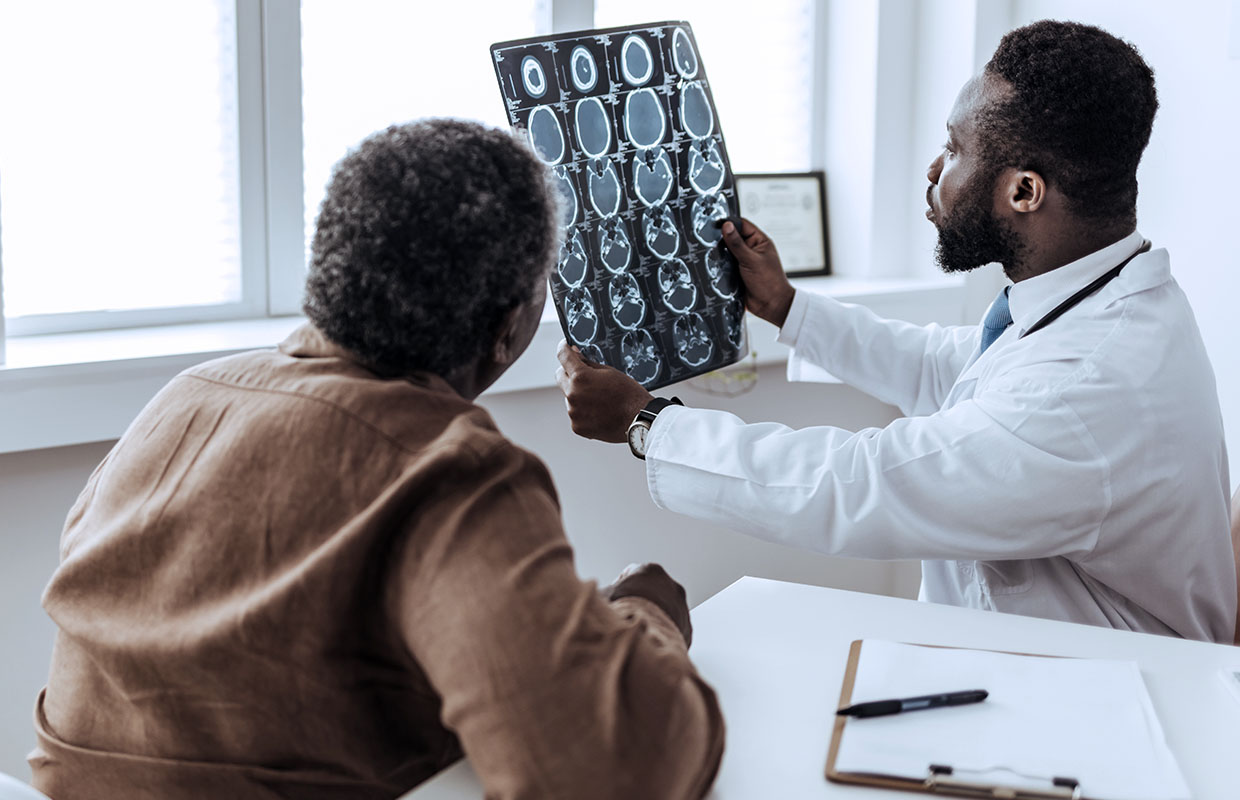 doctor views brain MRI with a patient next to him