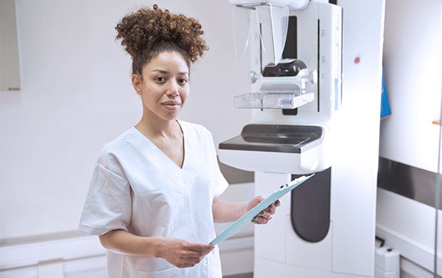 a female nurse stands in front of a medical machine