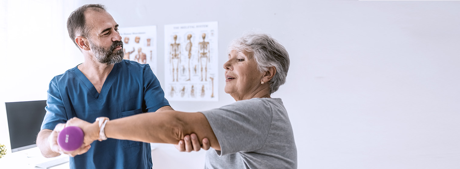 middle age male nurse helps elderly female patient lift her arm while holding weight