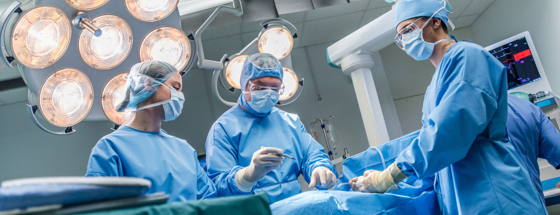 three surgeons in operating room