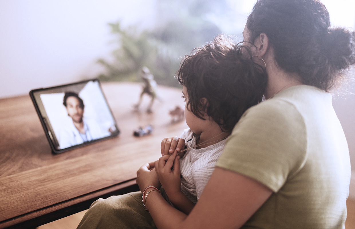 mother and young boy talking to a doctor on ipad