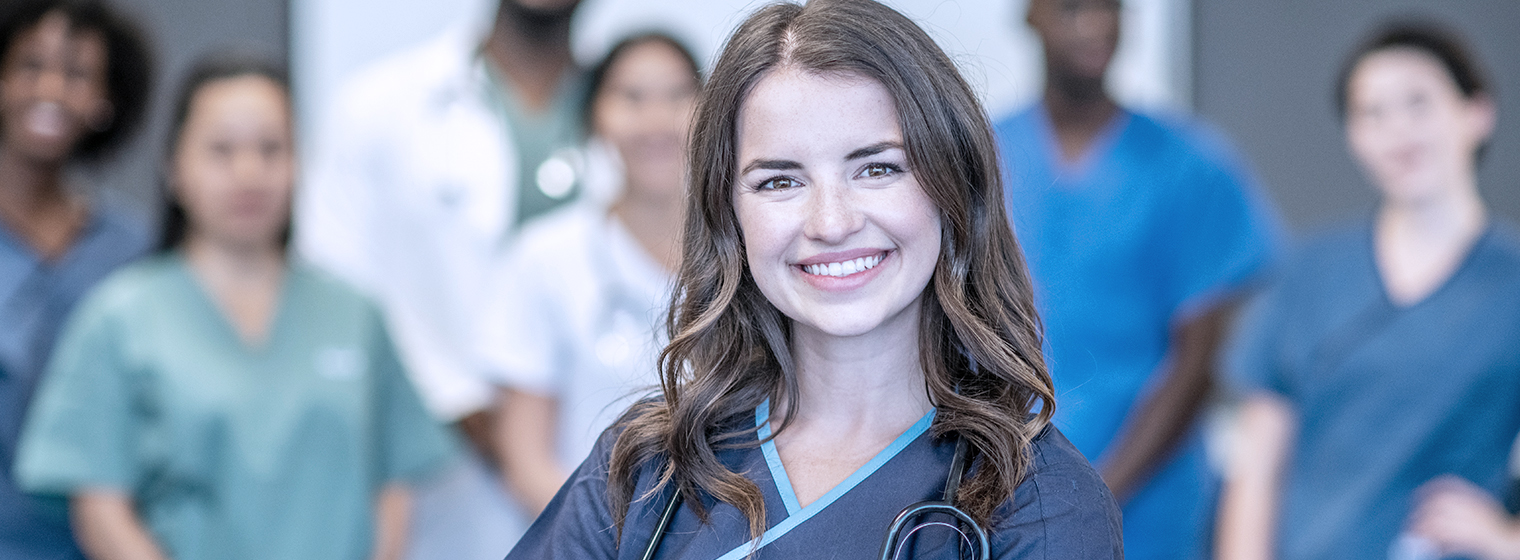 nurse stands for a photo with her team.