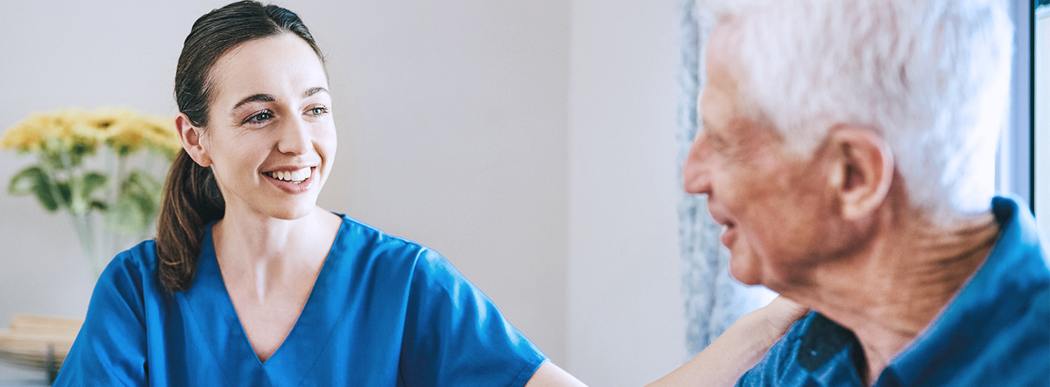 Nurse comforts senior male cancer patient.