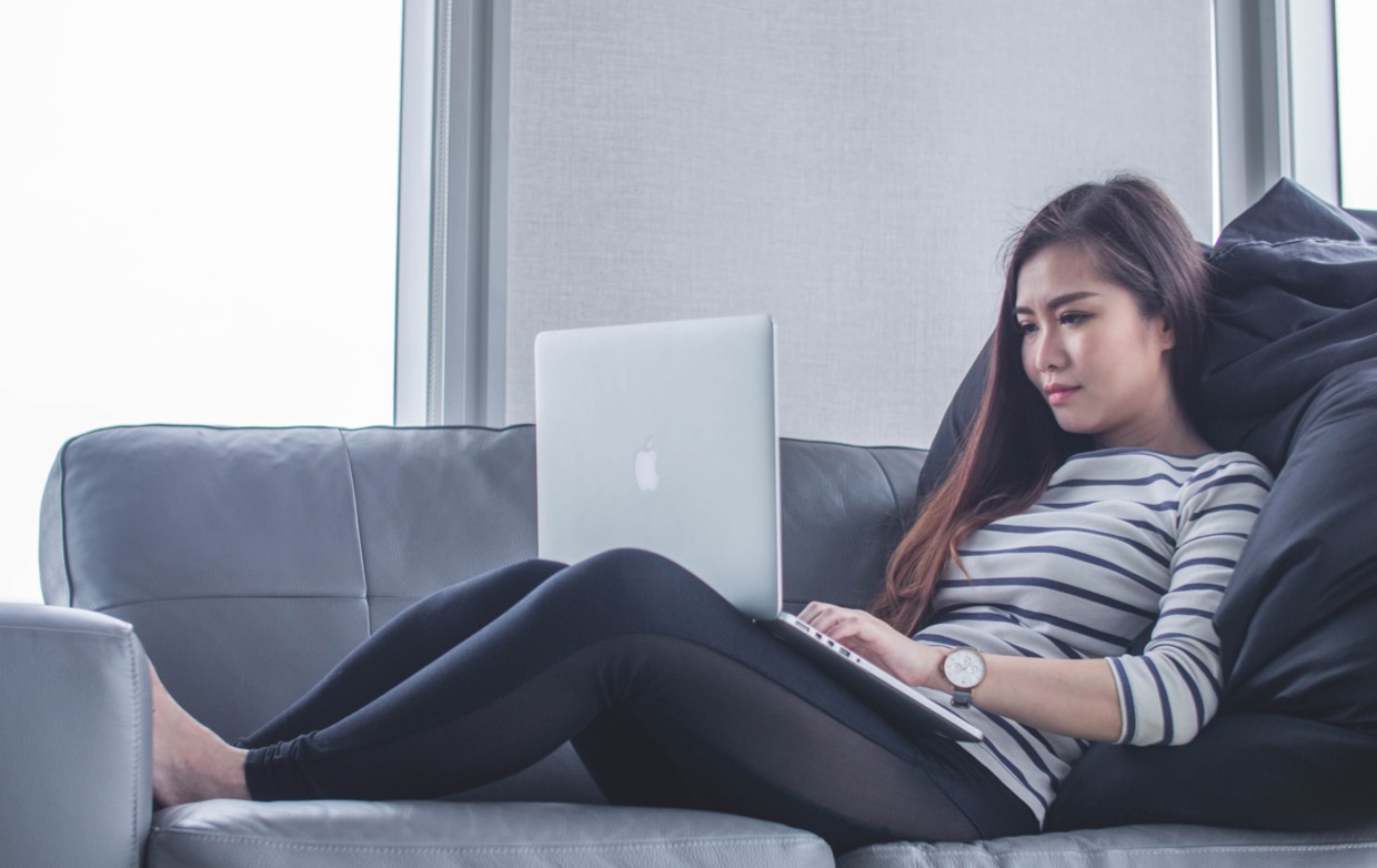 A woman on a couch on her laptop