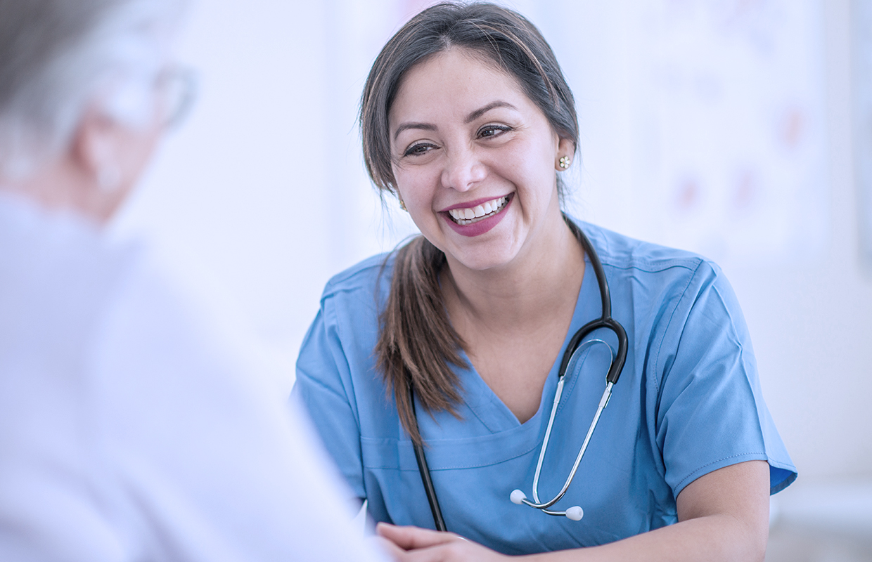 Female nurse comforts female cancer patient.