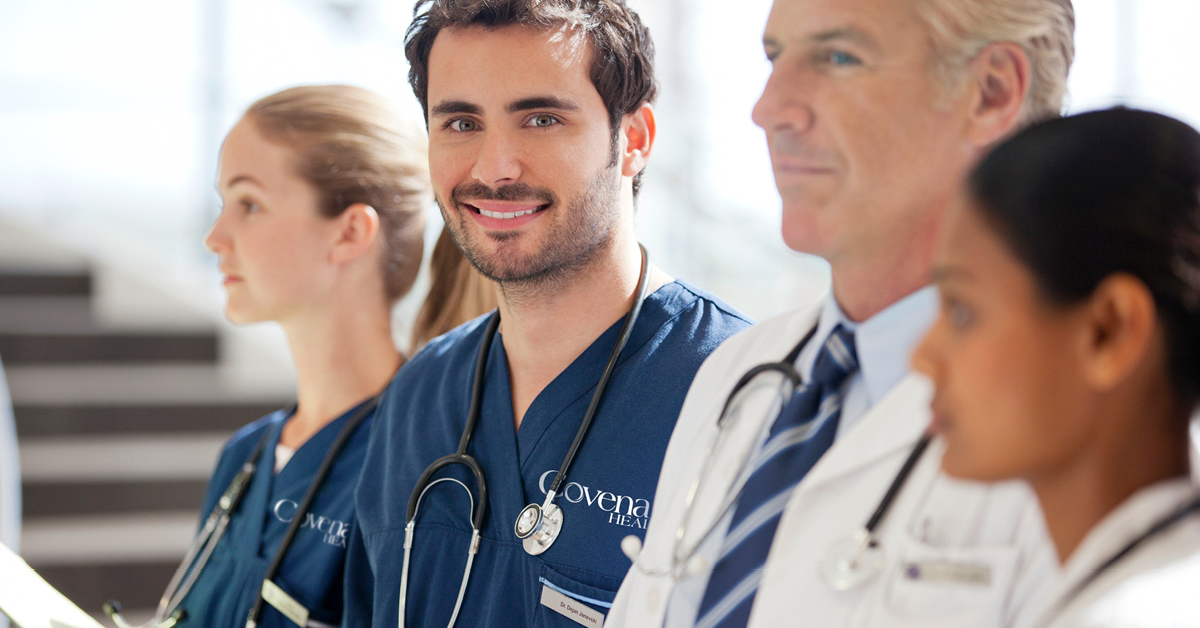 Four medical Covenant staff members with one young male nurse smiling at camera