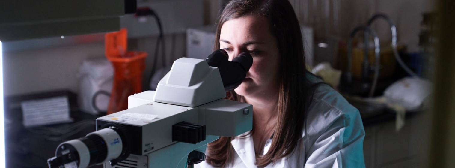 A doctor looking into a microscope