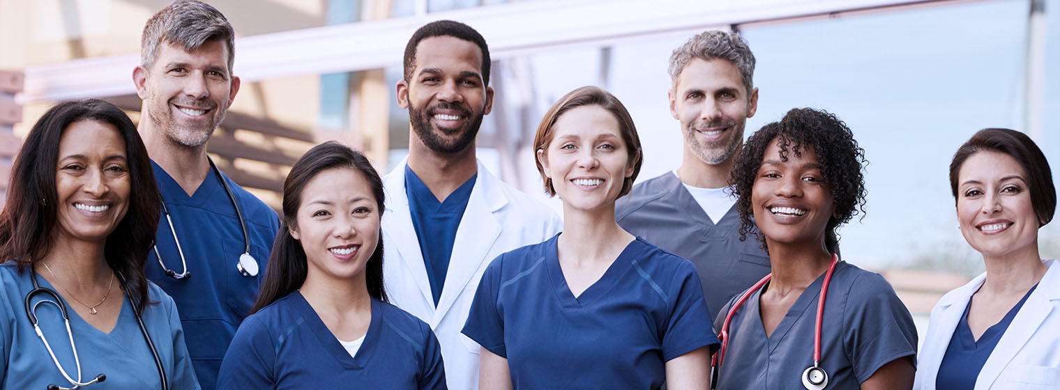 a team of doctors and nurses pose for a group photo
