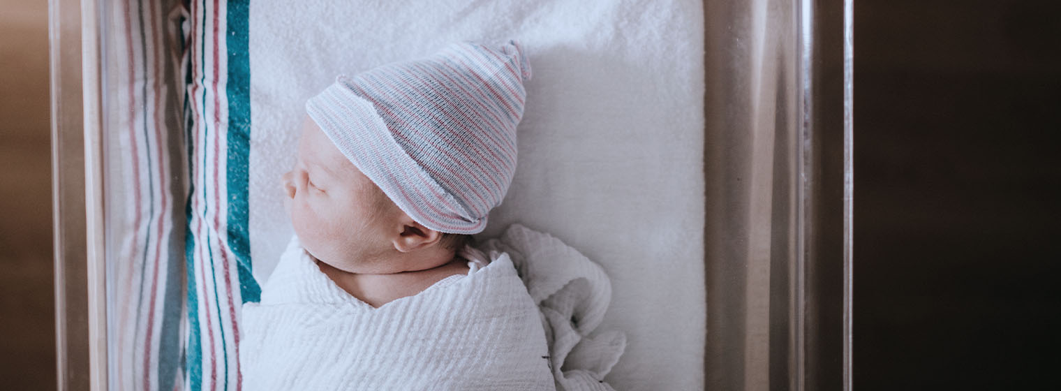 Newborn baby sleeps in swaddle after being born at a Covenant Health hospital.