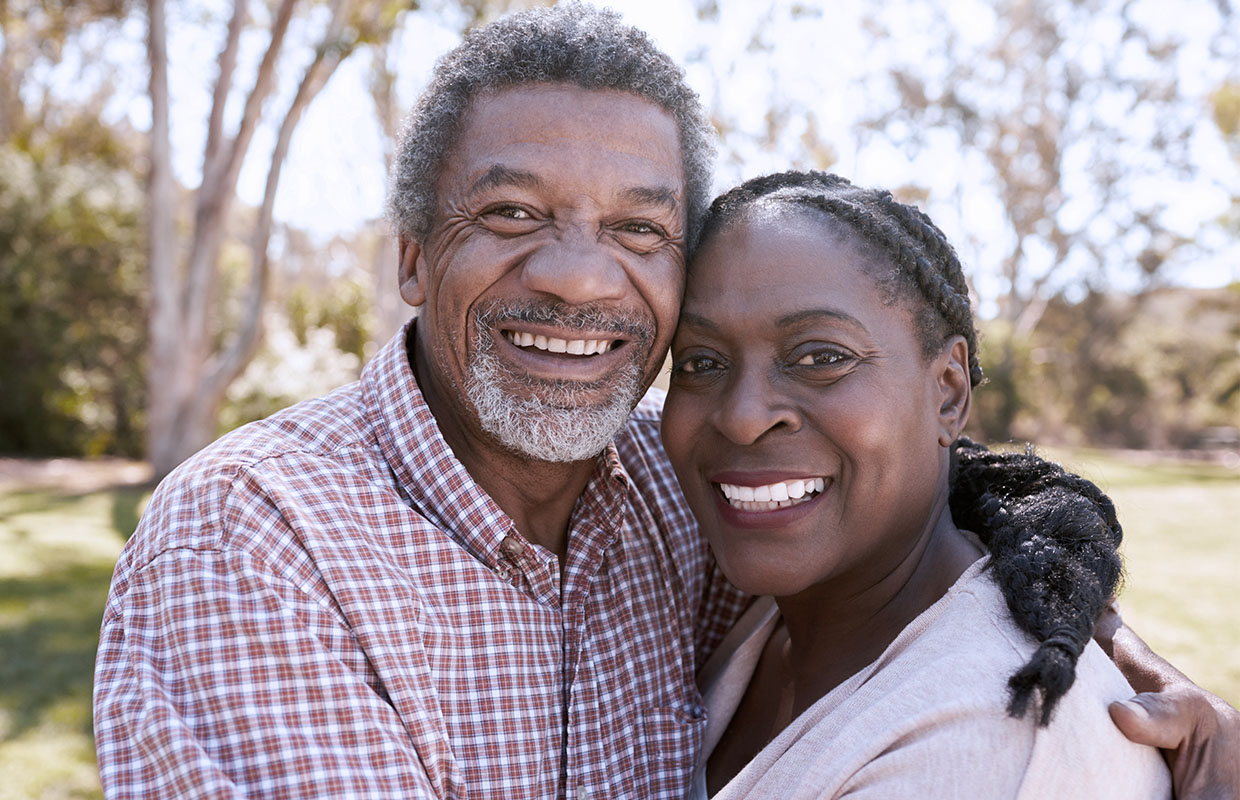 a middle aged couple hug and smile for a camera