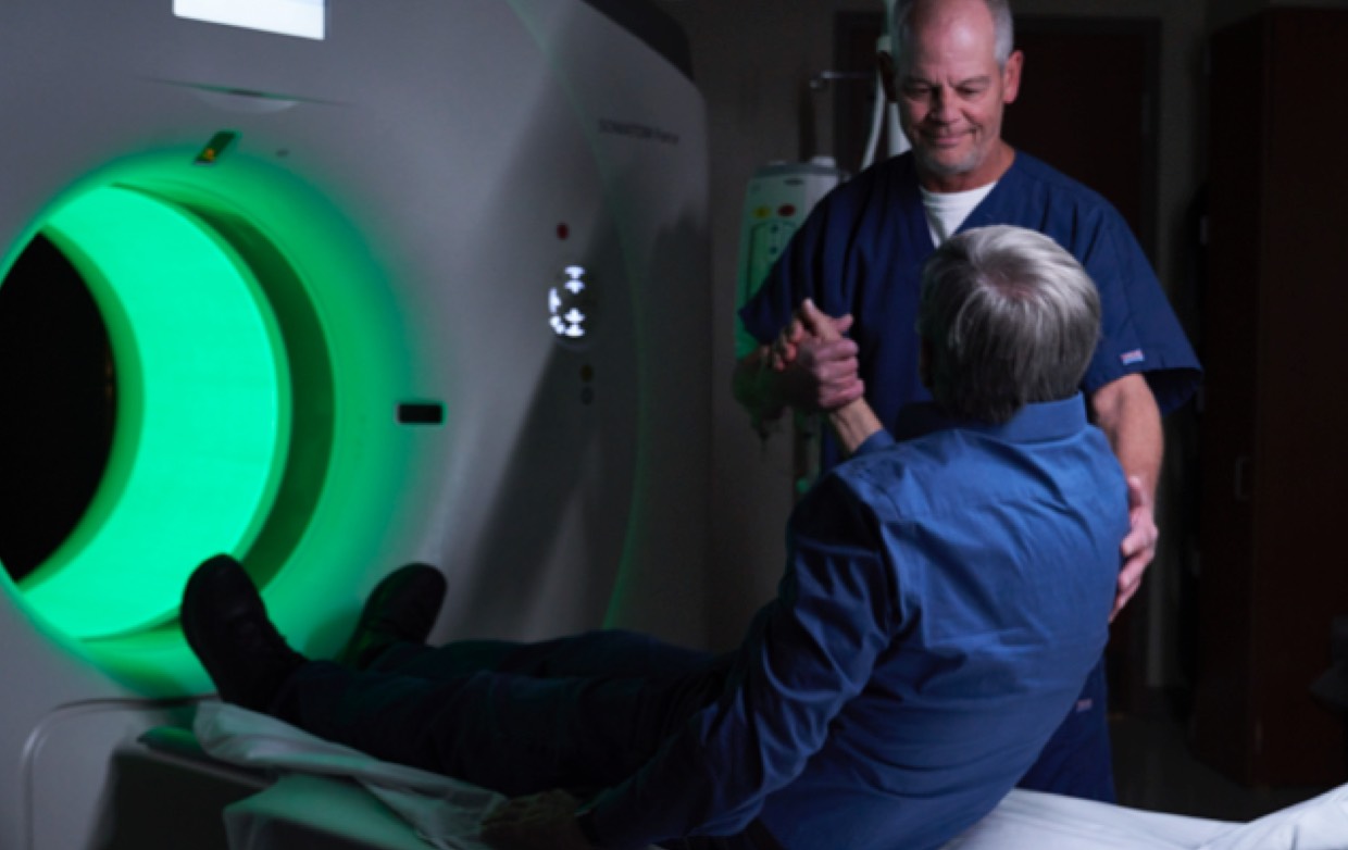 A Neuroscience employee comforting a patient before they get scans.