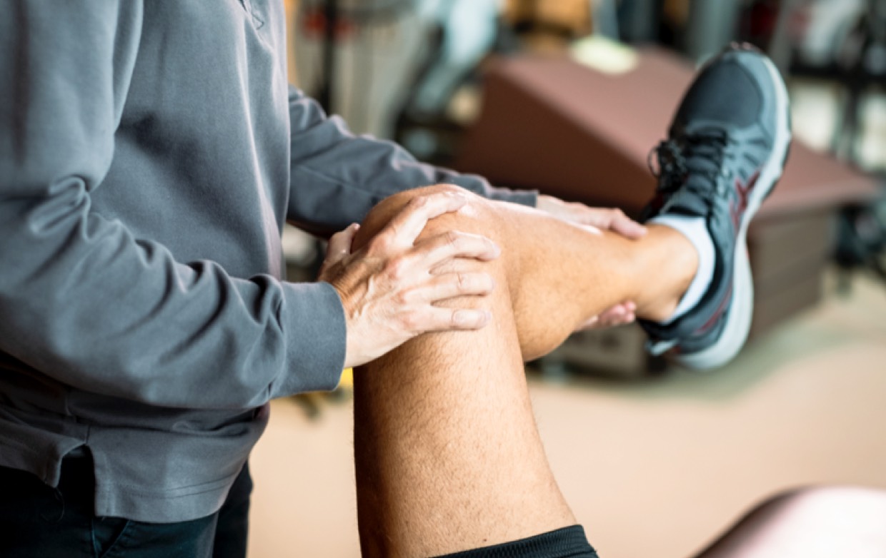 A physical therapist working on a patient's knee