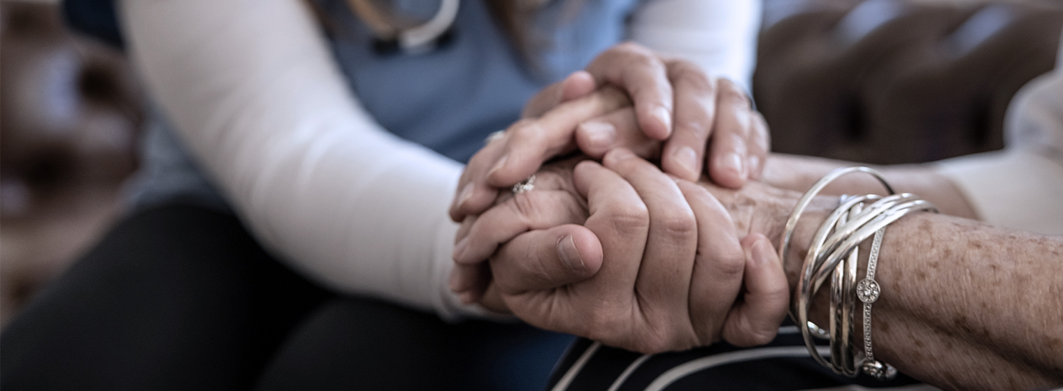 a medical professional holding the hand of a patient