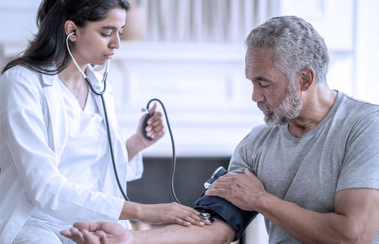 medical provider takes blood pressure older male patient