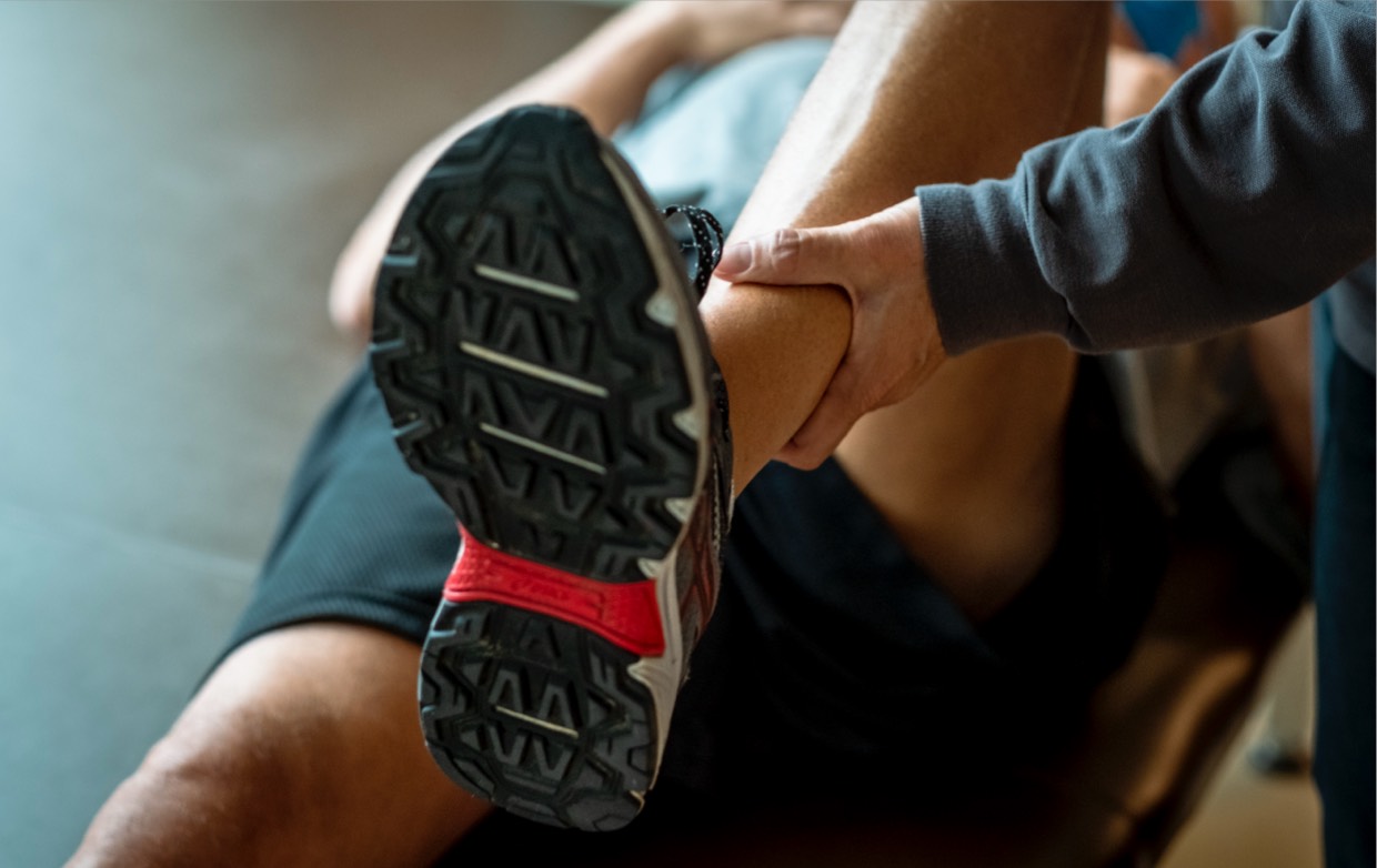 Closeup on a right leg with a PT stretching it