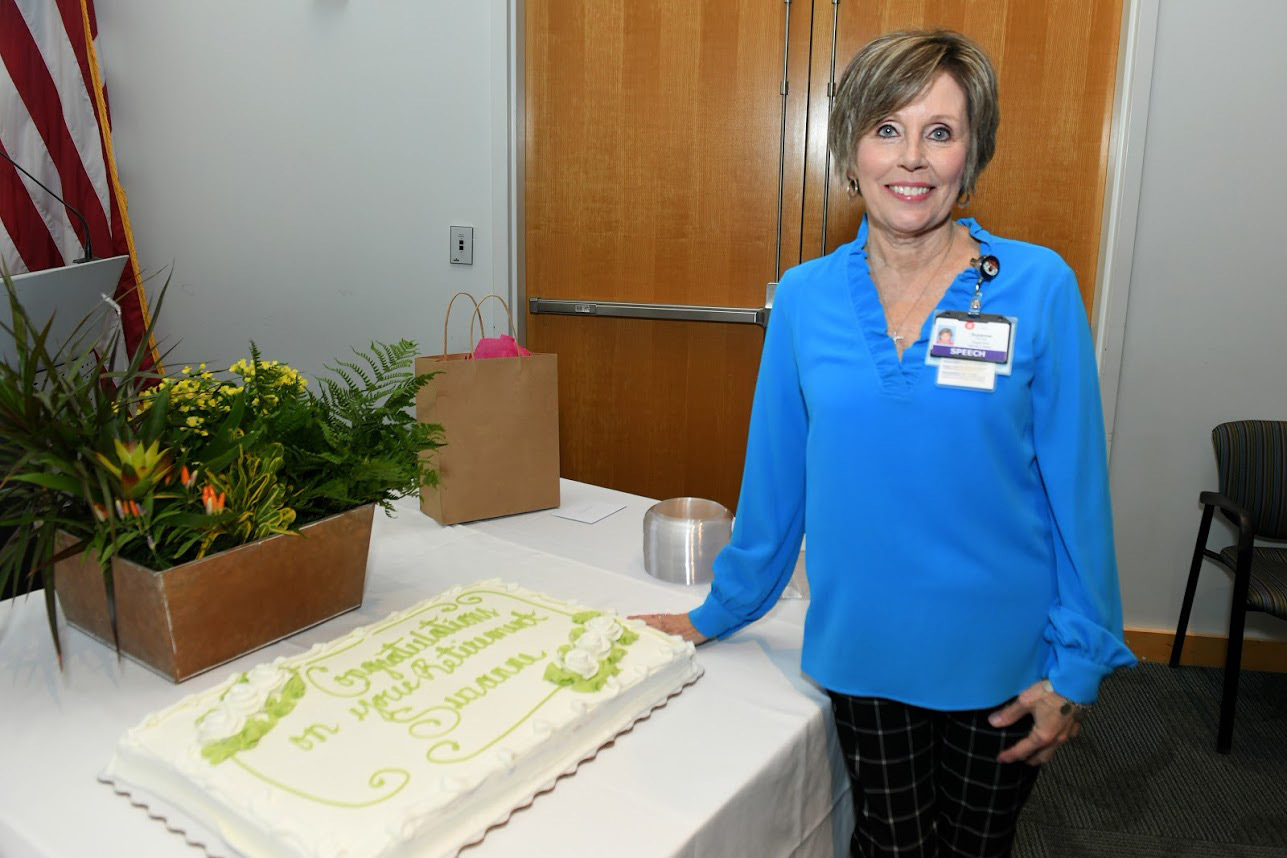 Suzanne Blocker with cake at retirement party