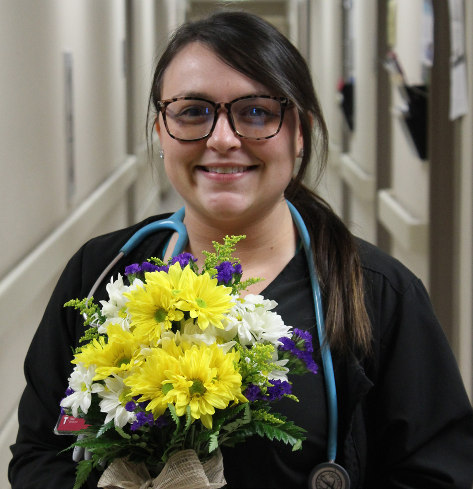 Kaylee Zalewski holding daisy arrangement.