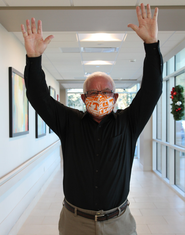 Patient Russell raising arms to show mobility.