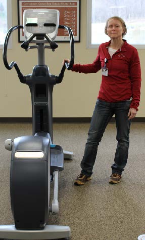 Rhonnda Cloinnger is standing next to an exercise bike.