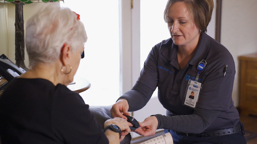 Paramedic takes a patient's vital signs in hospital-at-home setting.