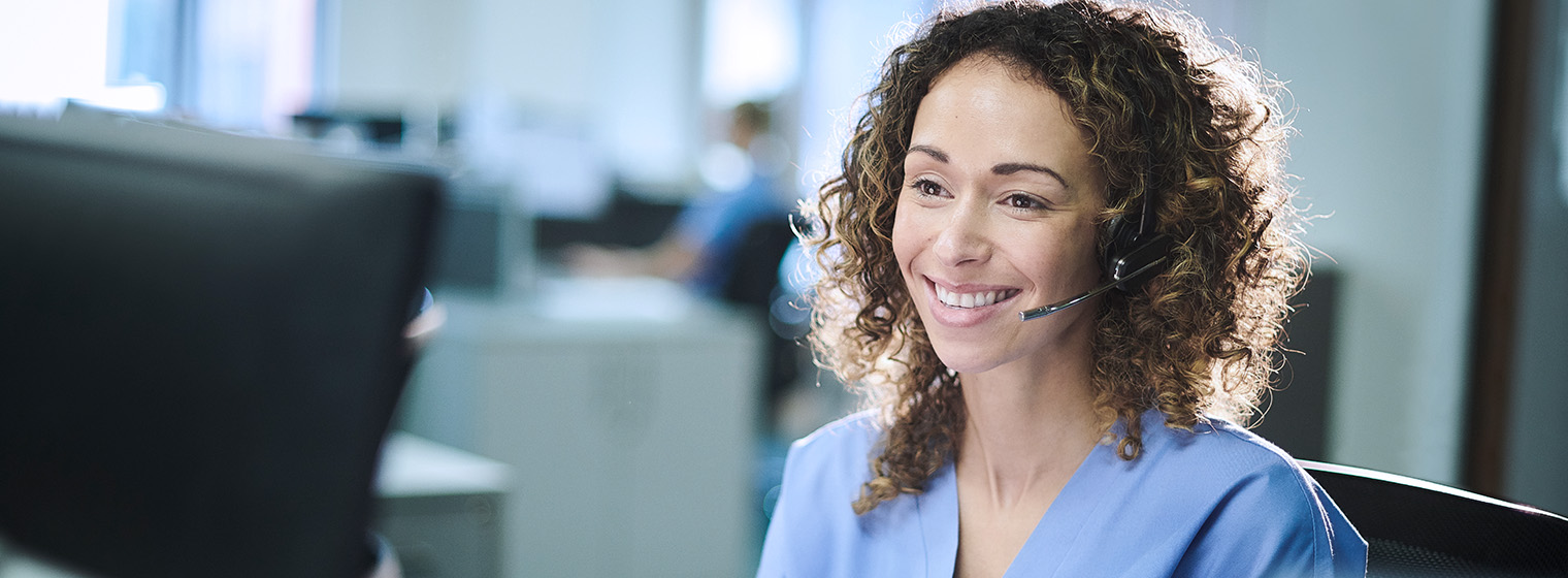 young female nurse smiling at registration desk