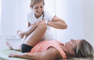 female physical therapist performs stretches on patient