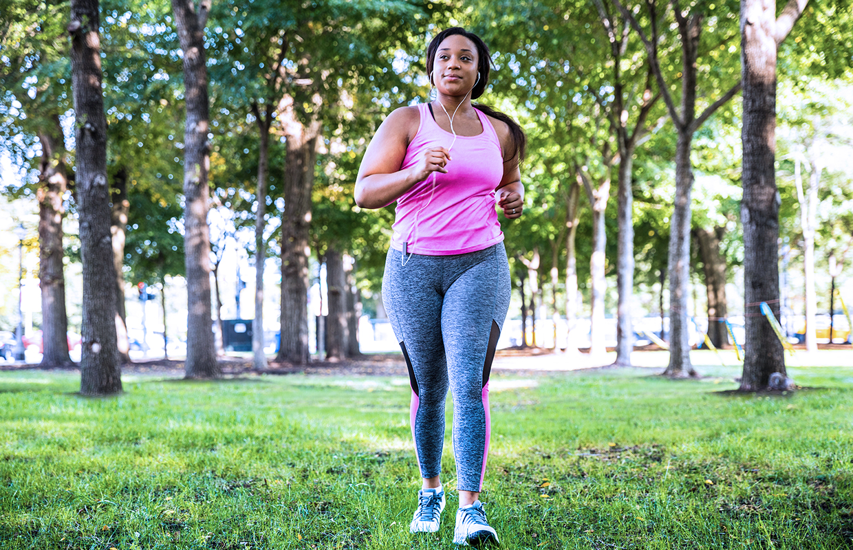 young woman running through a park