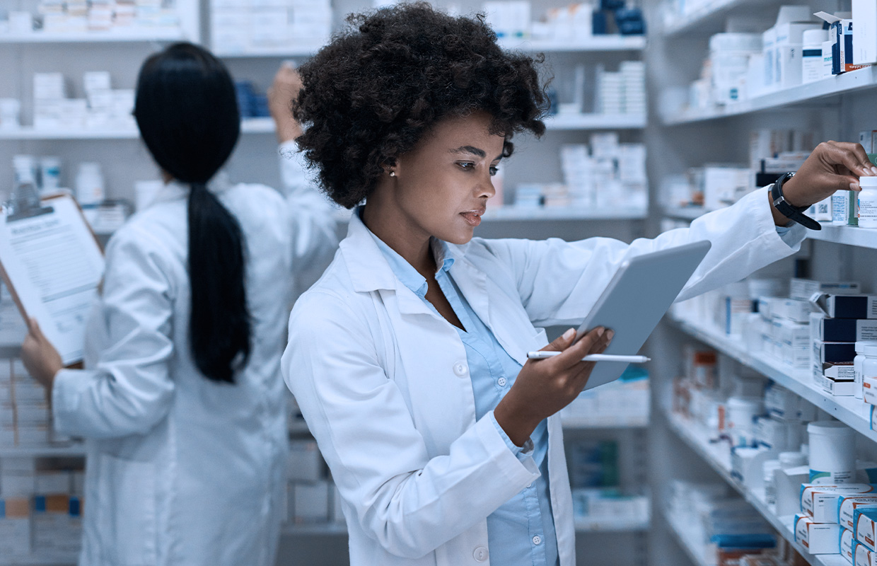 young female pharmacist looking at ipad and collecting medications