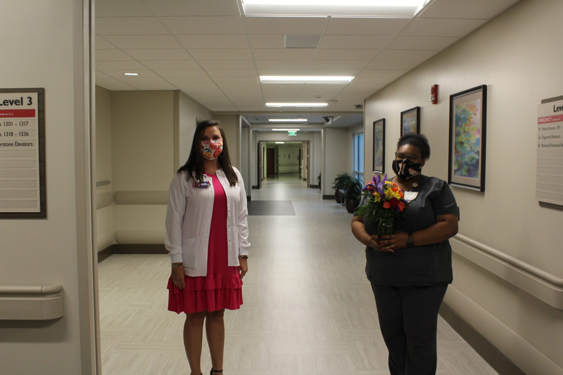 Lauren Cade in white sweater and Myleshia Carter holding flowers.