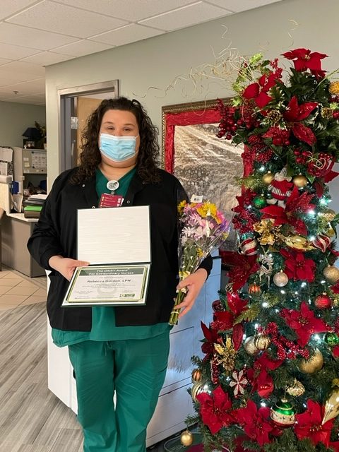 Rebecca Gordon with her certificate and DAISY arrangement.