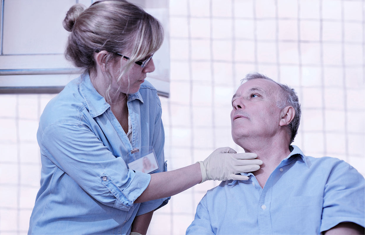 female speech therapist helping elderly man swallow