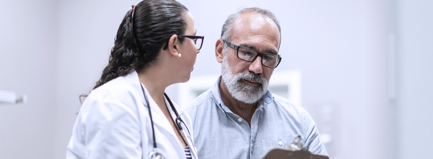 Female doctor reviews treatment plan with middle-aged male patient.