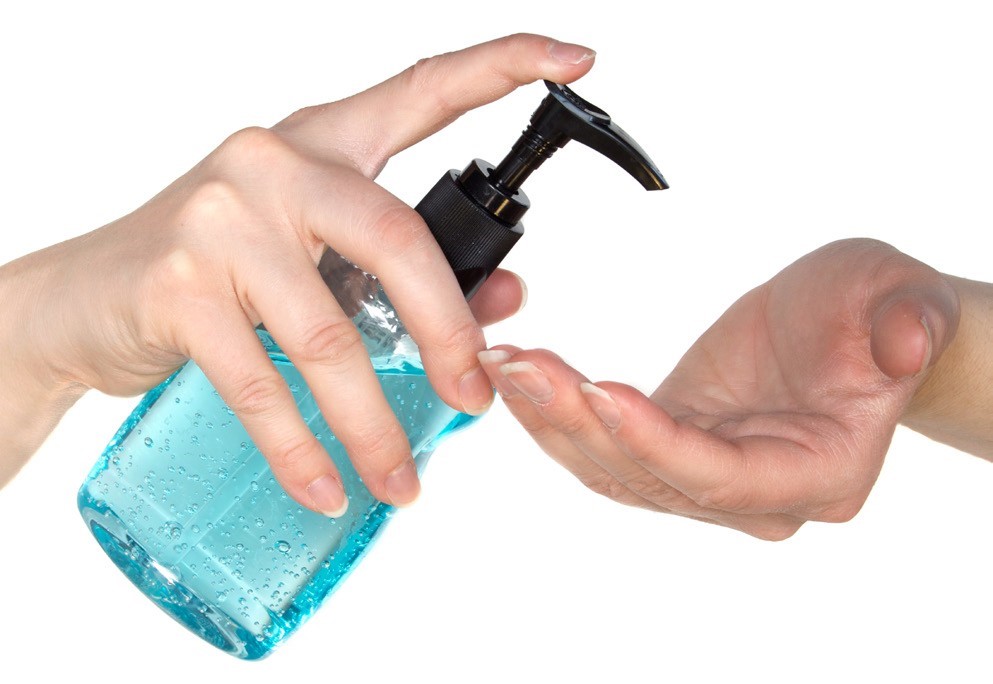 Bottle of hand sanitizer pumping into hand.