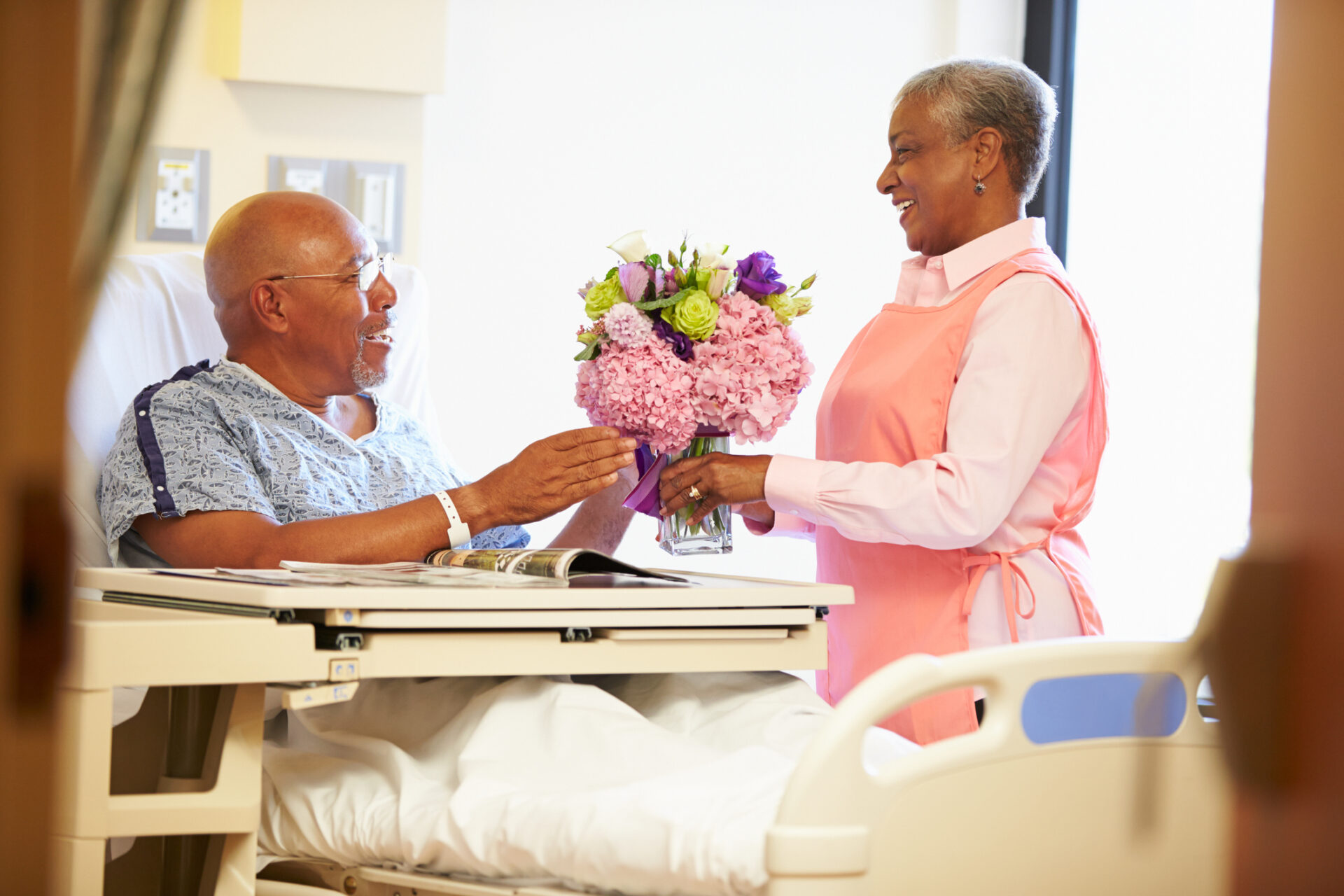 hospital volunteer delivers a card to a male patient