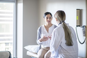 Doctor talks with female patient in exam room