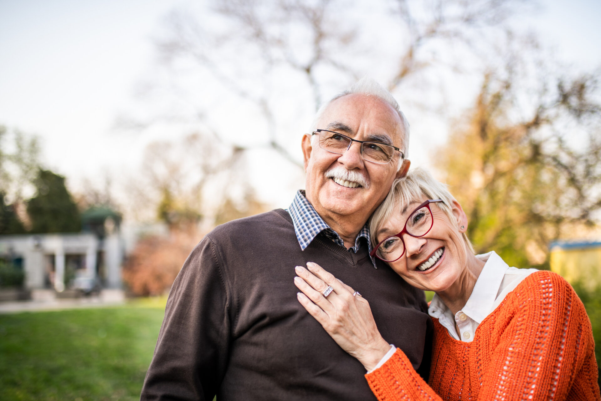 senior couple hugs outside