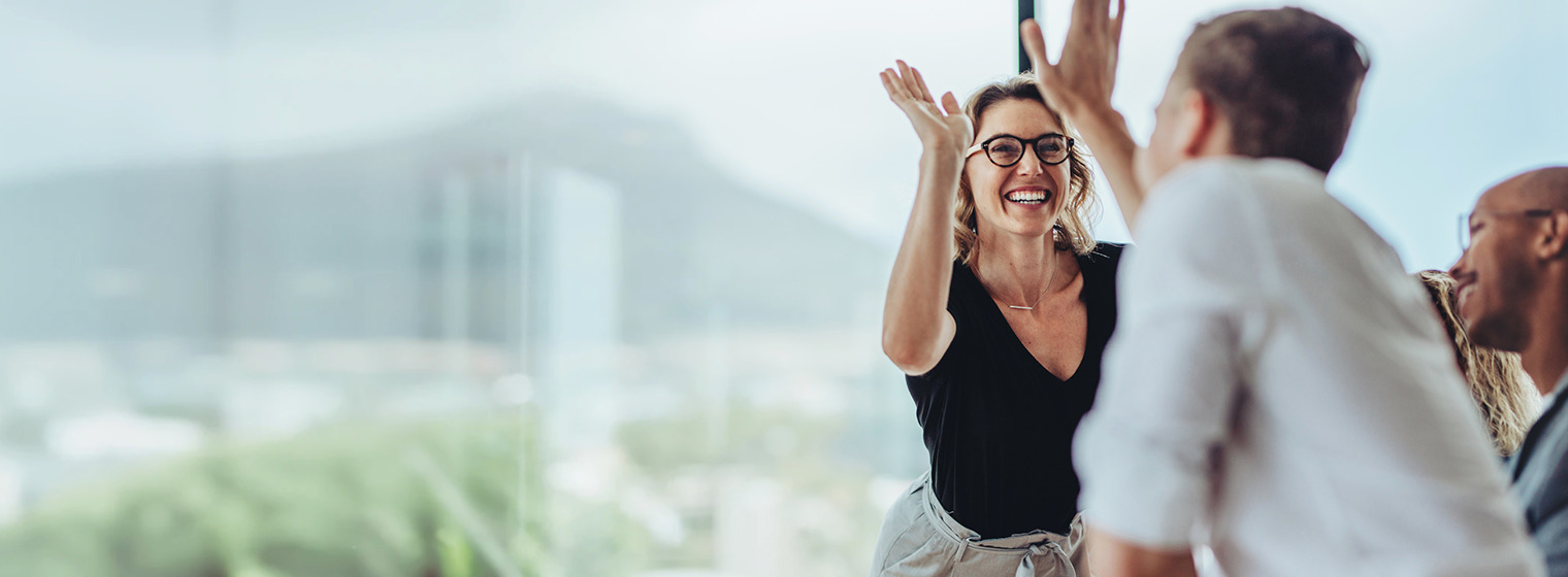 adult female and male high fiving in an office