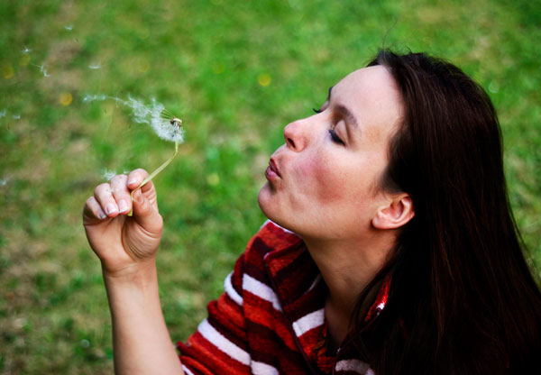 blowing on a dandelion