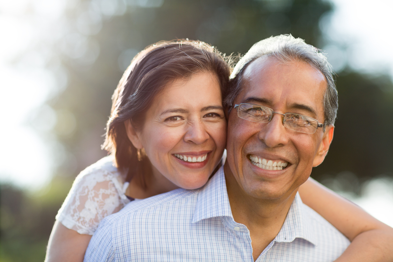 senior male and female smiling outside