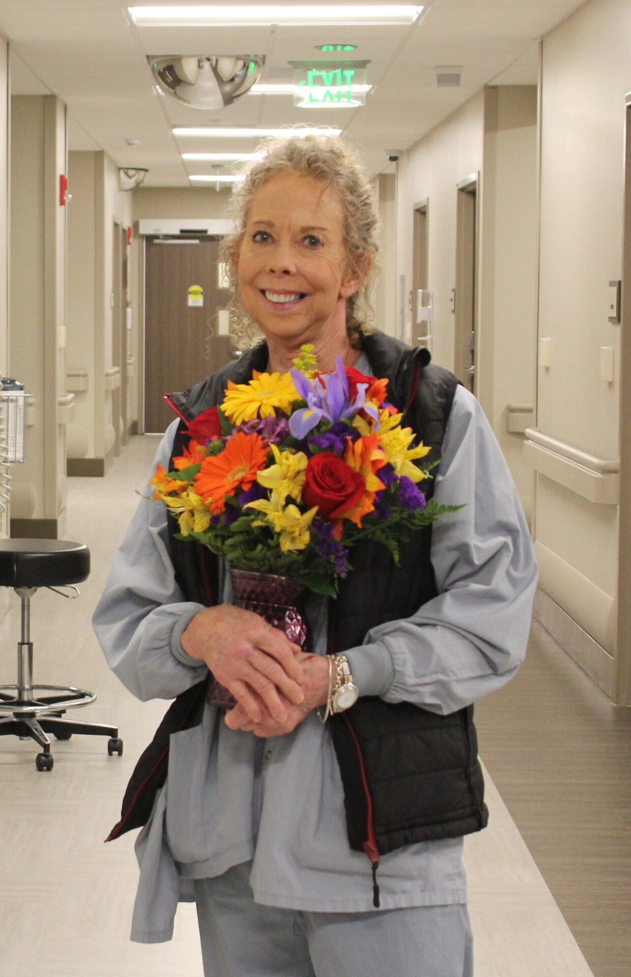 Linda is pictured standing holding her flowers after BEE celebration.