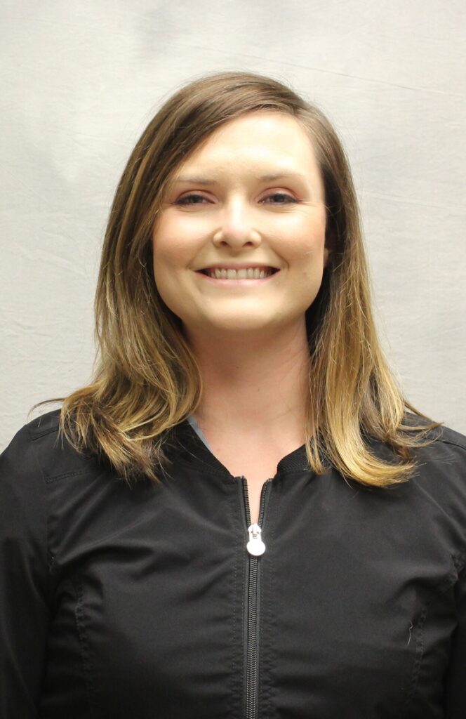 Emly Ingram smiling in black scrubs.