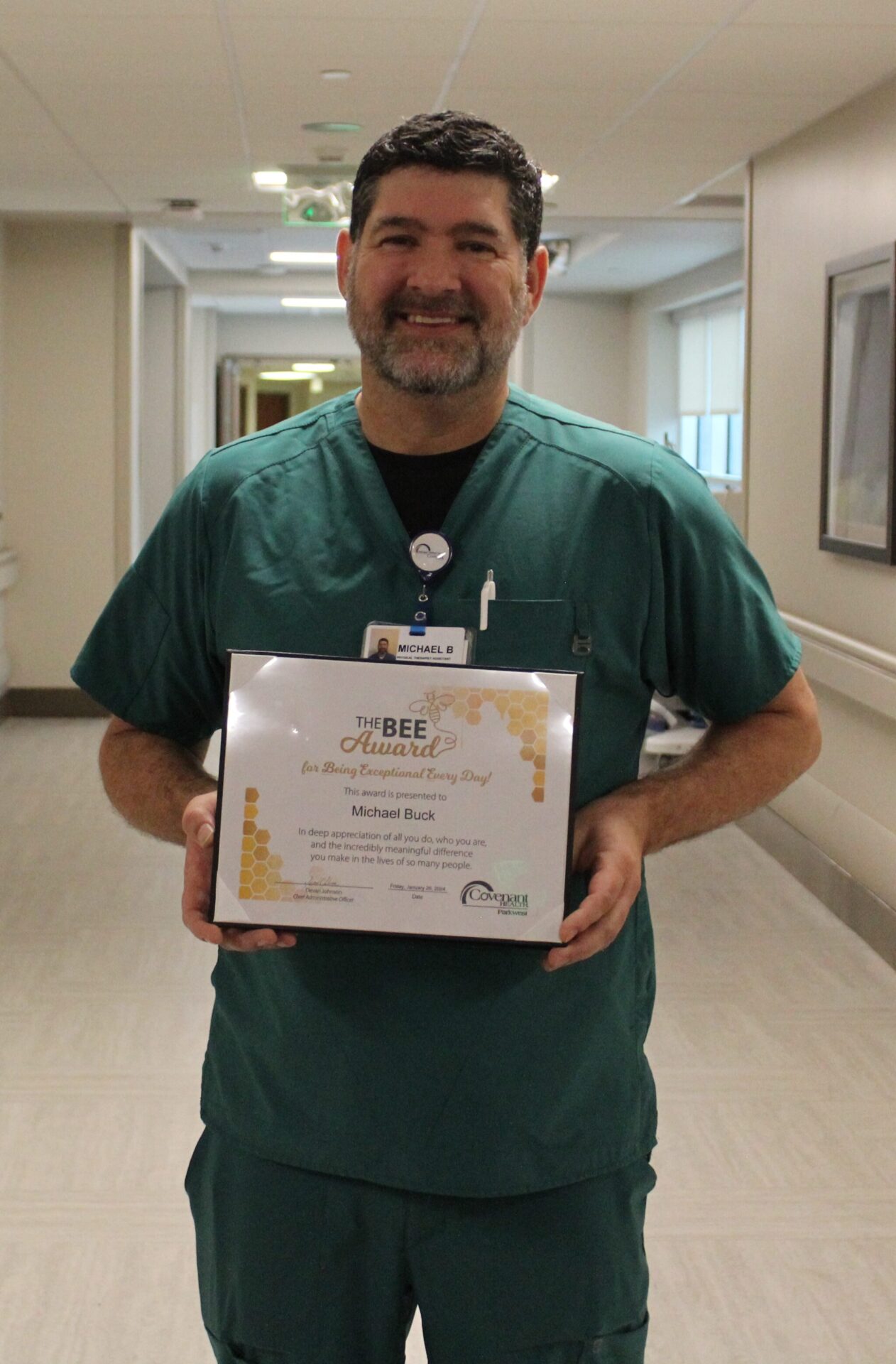 Michael smiling holding his BEE certificate.