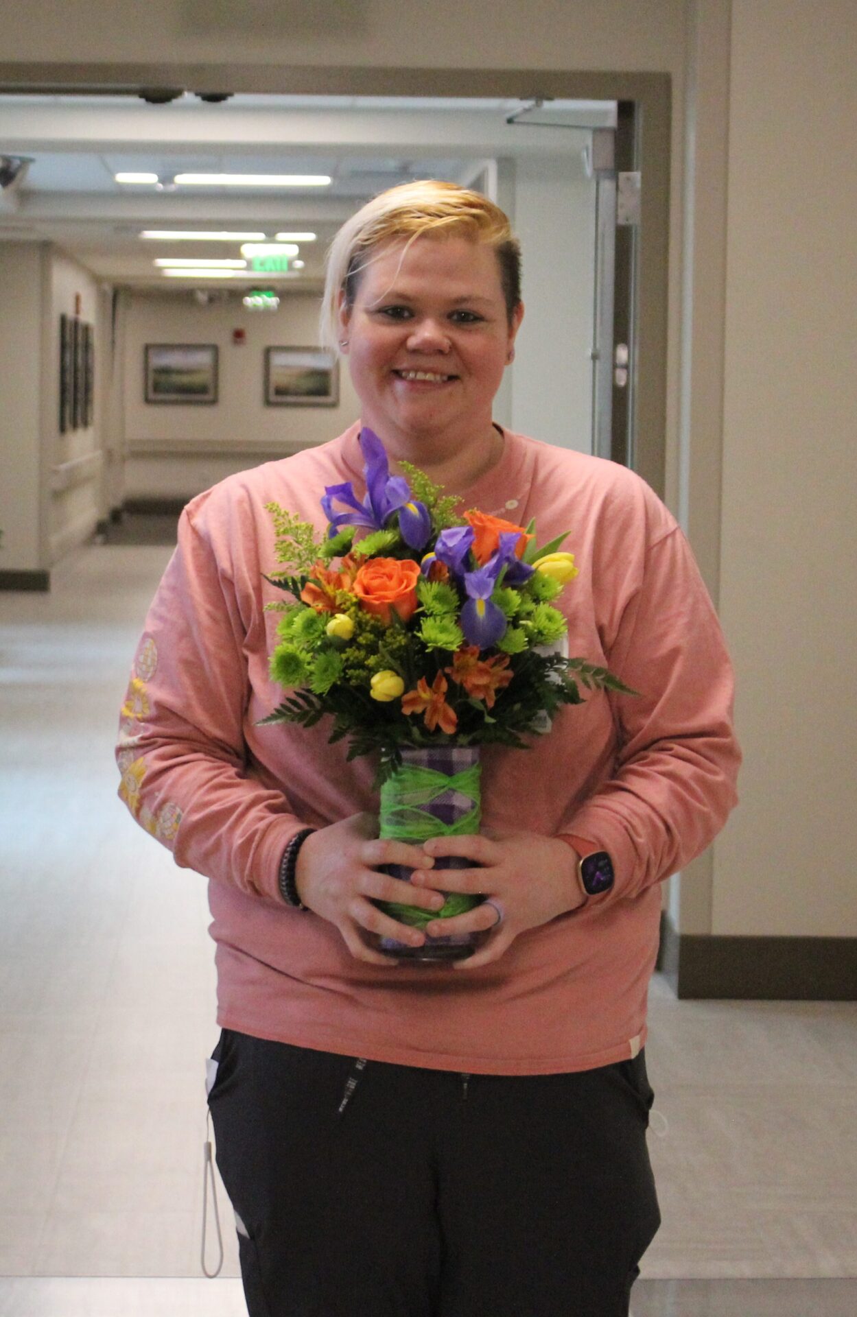 Patience pictured by herself holding her mixed flower arrangement.