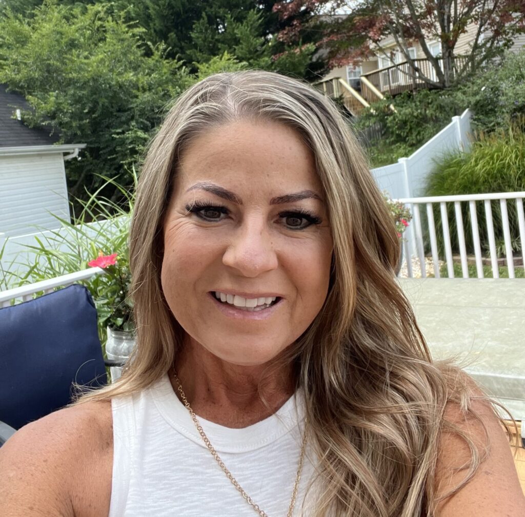 Melisa wearing white tank top, smiling.